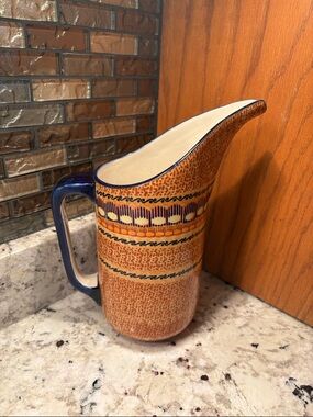 Speckled Ceramic Pitcher with Blue Handle and Decorative Band